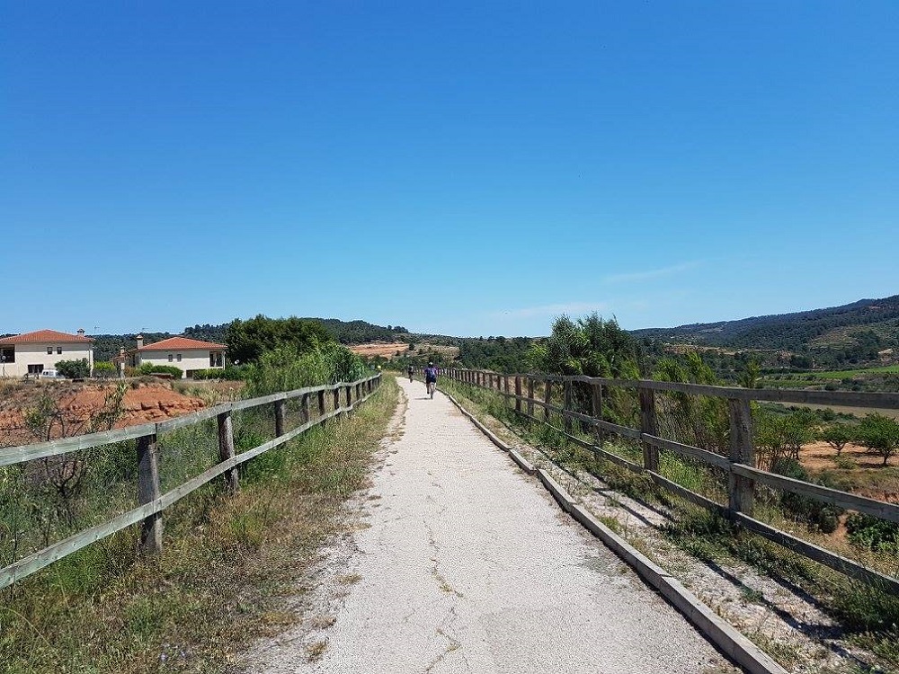 Largas rectas por un paisaje ondulado, variado y abierto, donde se dan cita huertas frutales, casillas y granjas nos acercan a Tortosa.