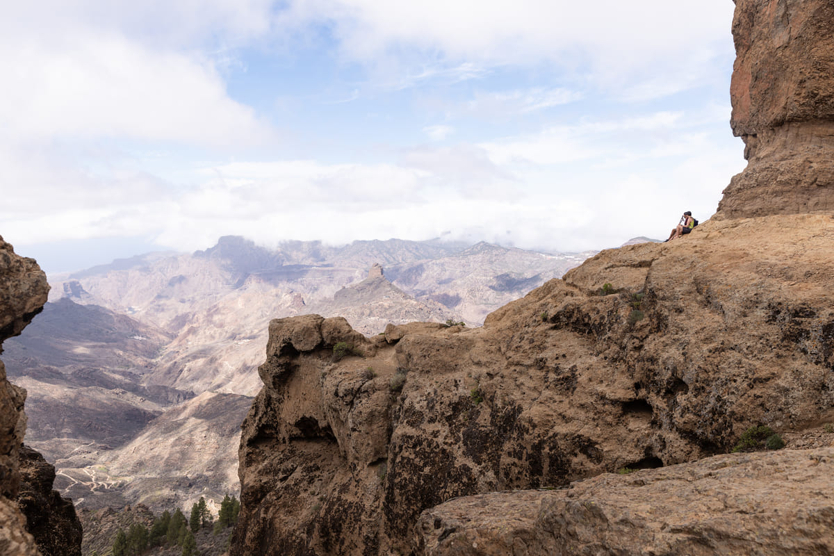 Dos senderistas recostados en la base de Roque Nublo. Fotografía: Júlia Miralles Larrègola